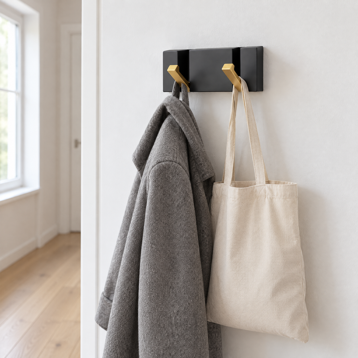 Wandgarderobe im hellen Flur mit Wollmantel und Stofftasche an den Klapphaken