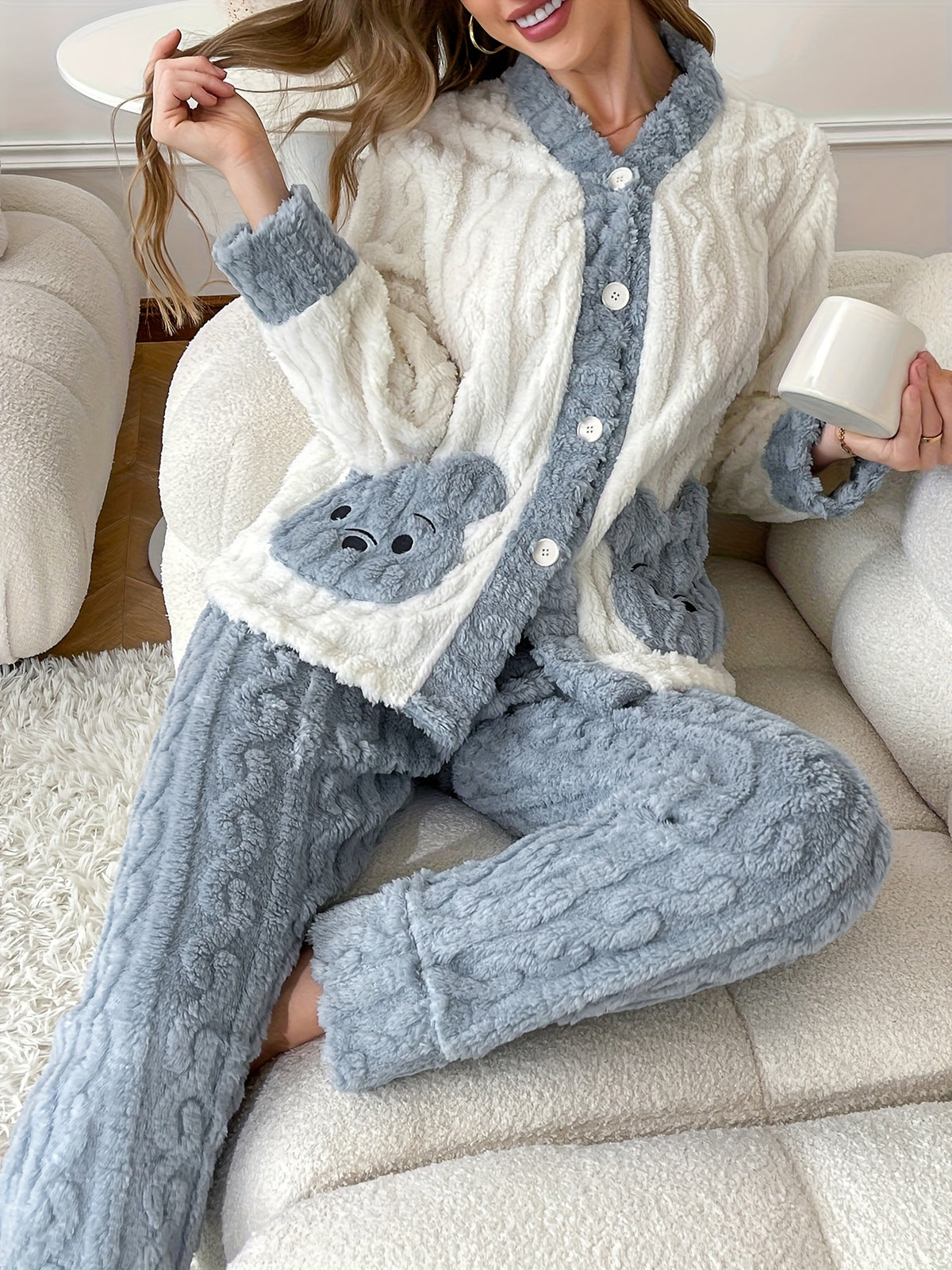 Flanell Pyjama Damen in Creme und Blau, Frau sitzt lächelnd mit Tasse auf dem Sofa
