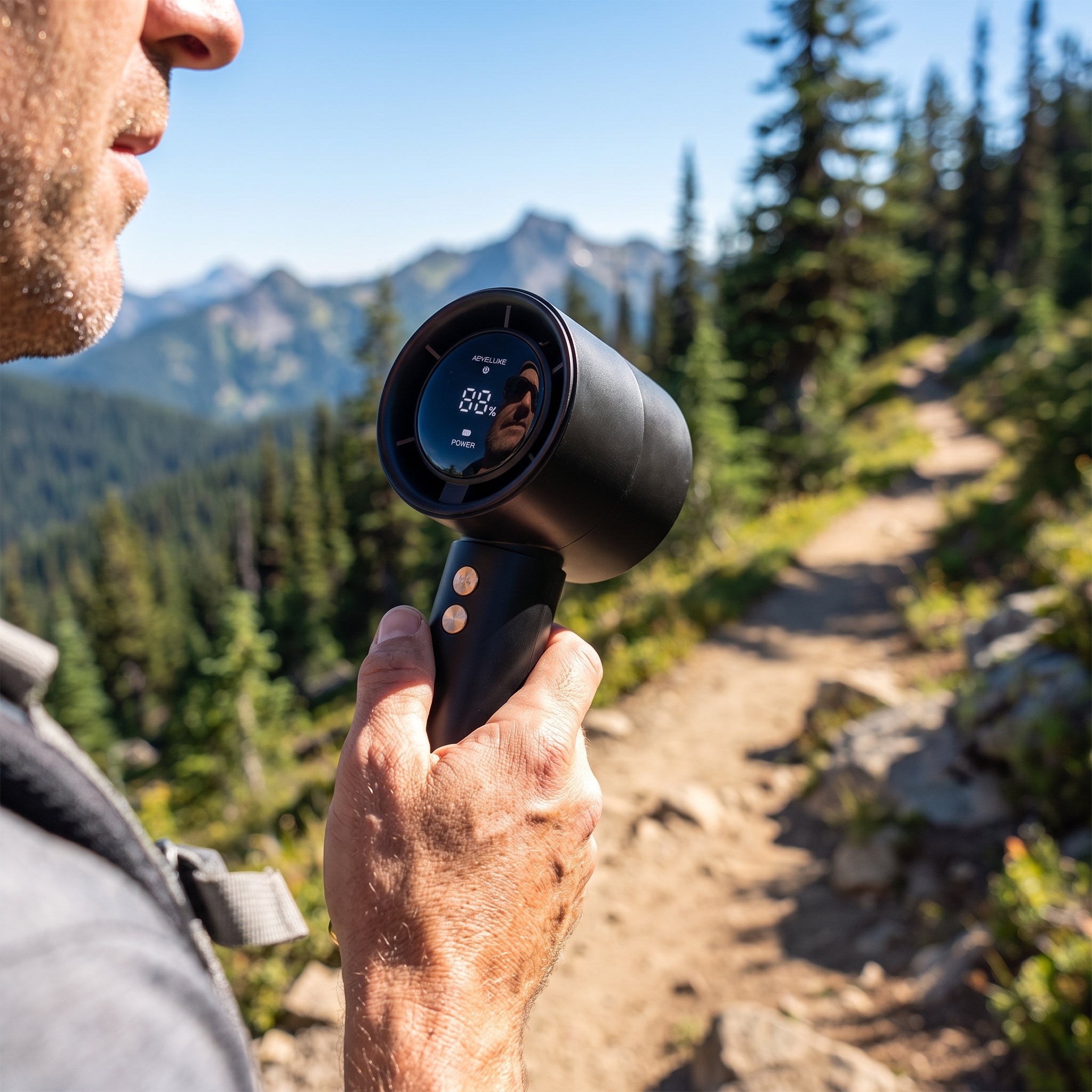 Tragbarer Handventilator beim Wandern in den Bergen