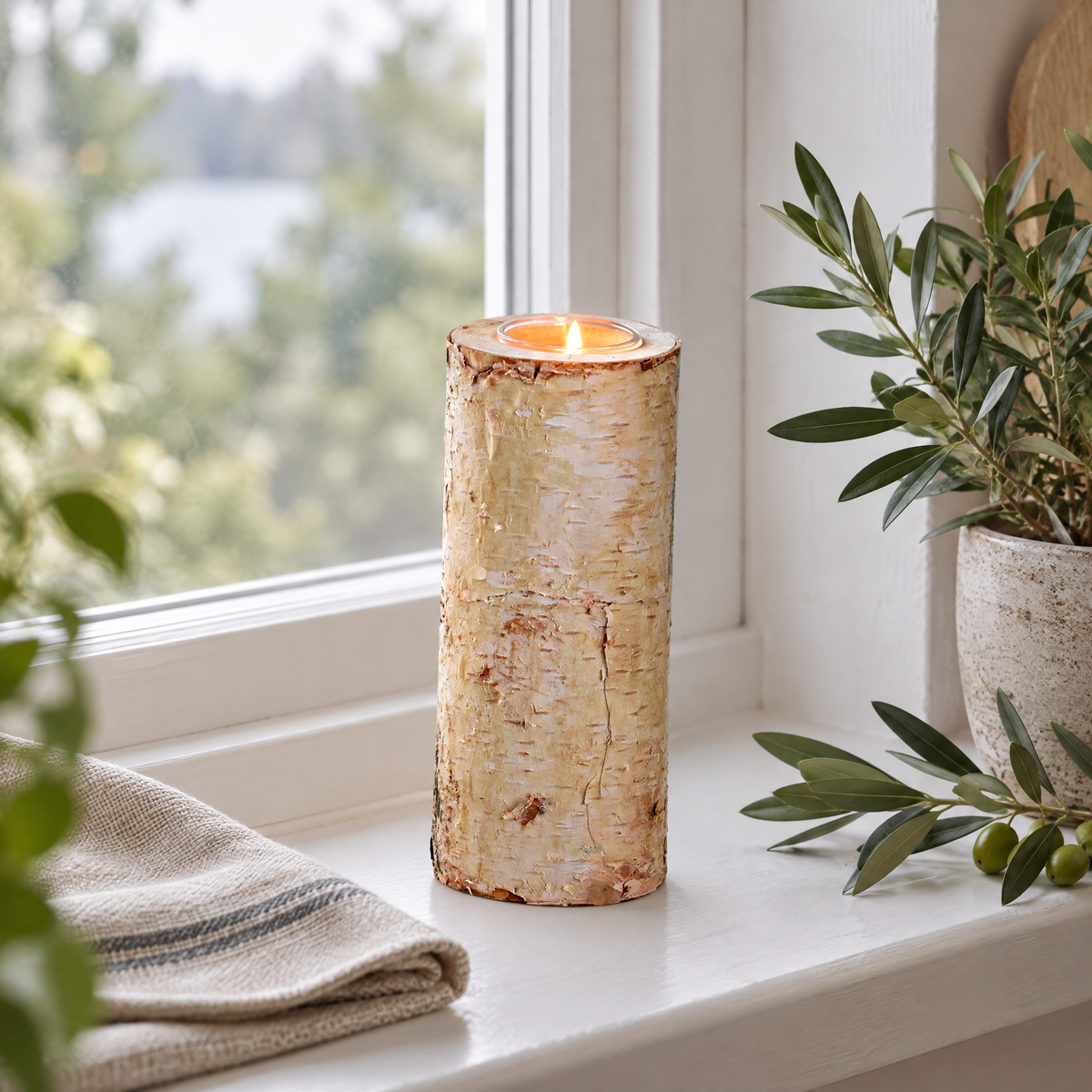 Kerzenhalter Holz aus Birke, 20 cm hoch, mit brennendem Teelicht auf der Fensterbank