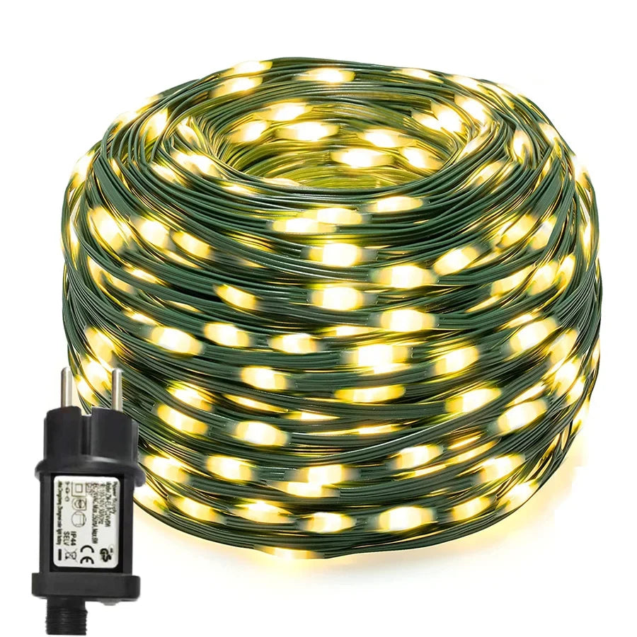Lichterkette außen in Warmweiß aufgerollt, grünes Kabel mit Steckernetzteil