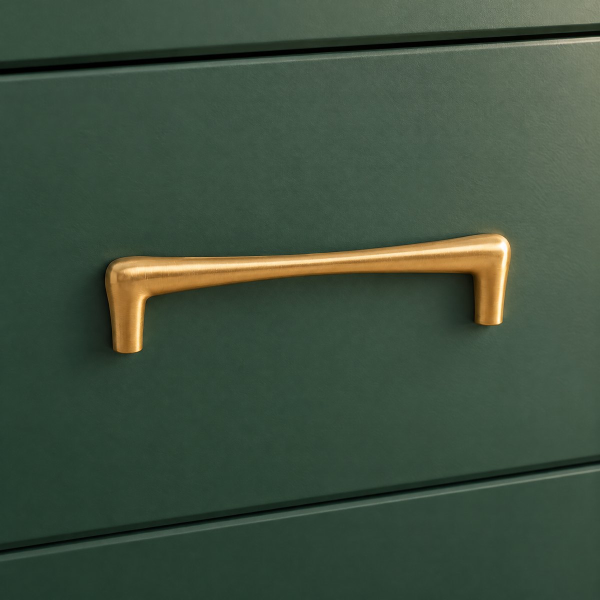 Goldener Möbelgriff in Tropfenform mit Lochabstand 128 mm an einer grünen Schublade