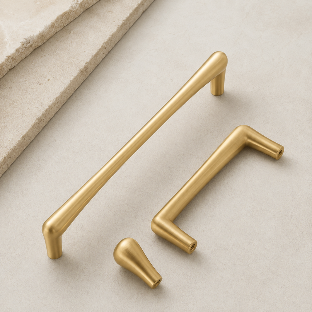 Goldene Griffe und Knopf in Tropfenform auf hellem Stein