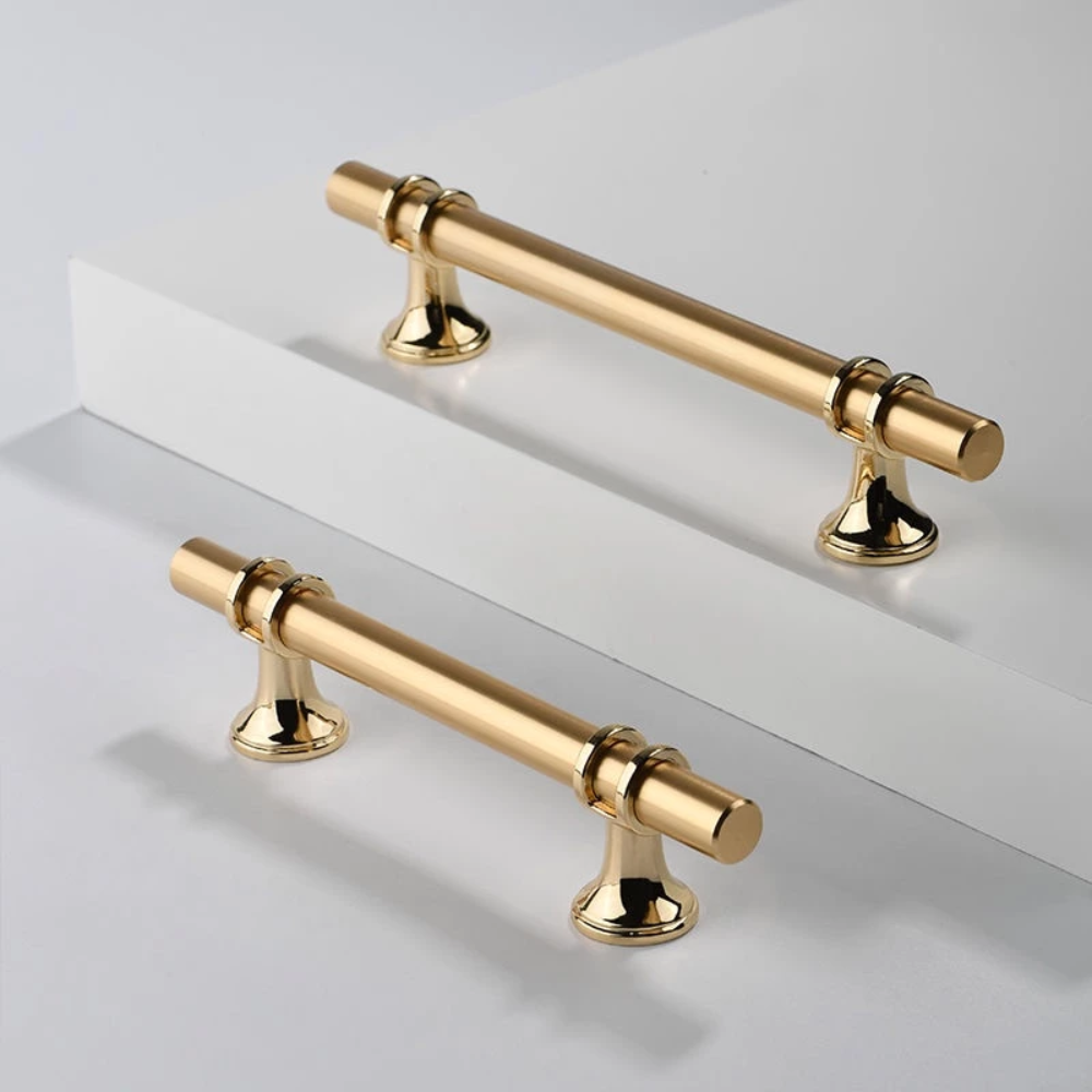 Zwei goldene T-Bar Griffe auf weißem Untergrund