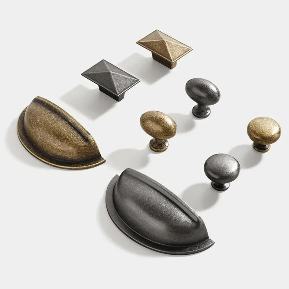 Knöpfe, Pyramidenknöpfe und Muschelgriffe in Antiknickel und Antikbronze auf weißem Hintergrund