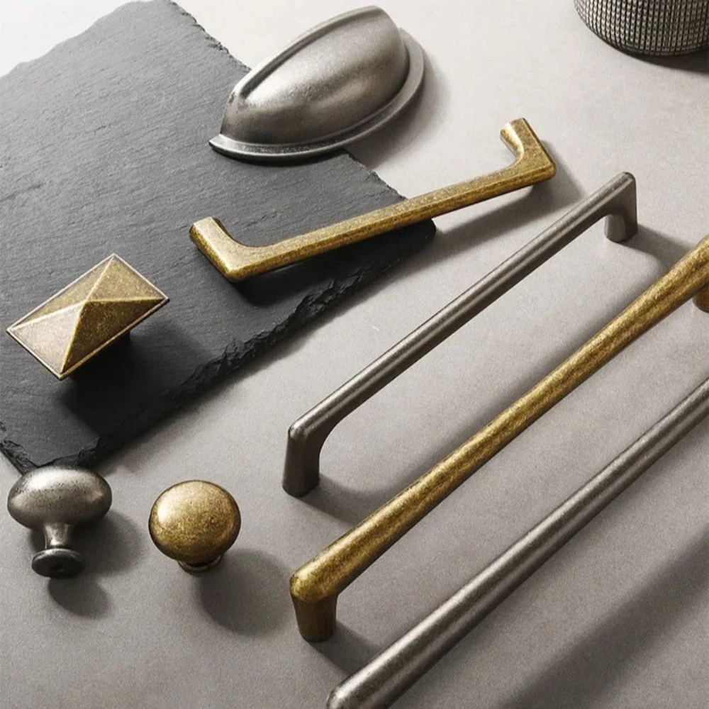 Übersicht verschiedener Vintage Griffe und Knöpfe in Antiknickel und Antikbronze auf Schiefer