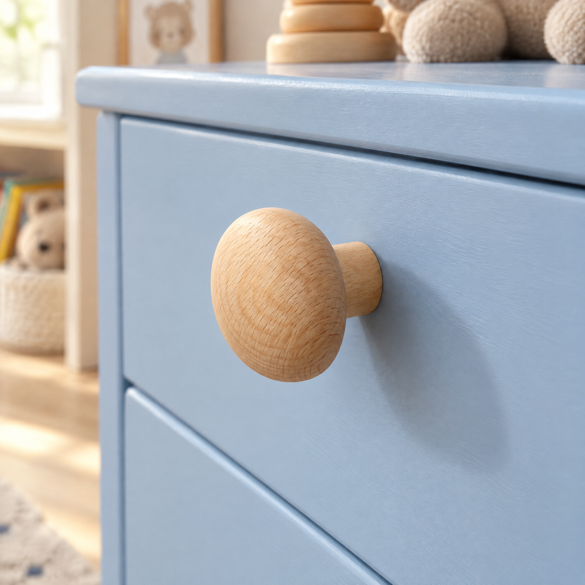 Möbelknöpfe Holz in Buche, runde Kieselstein-Form, an einer hellblauen Kinderzimmer-Kommode, seitlich mit sichtbarem Holzschaft
