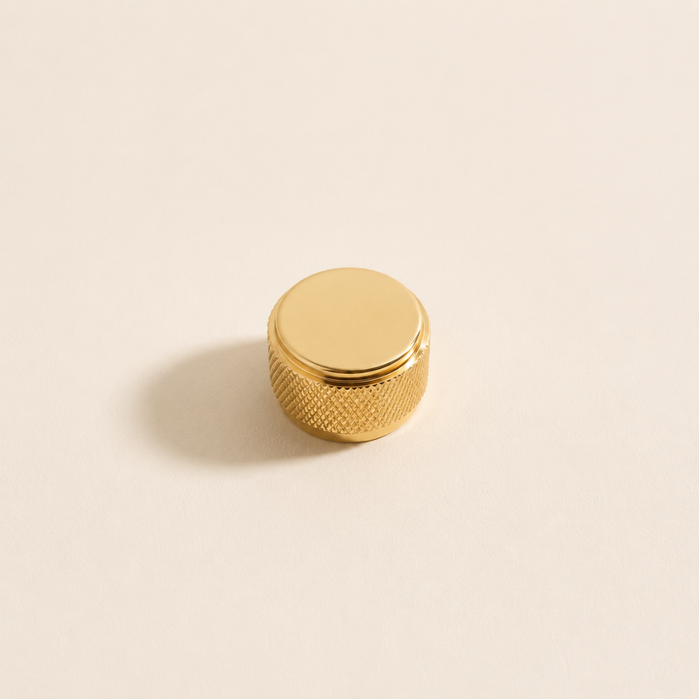 Goldener Zylinderknopf mit Ring auf hellem Hintergrund