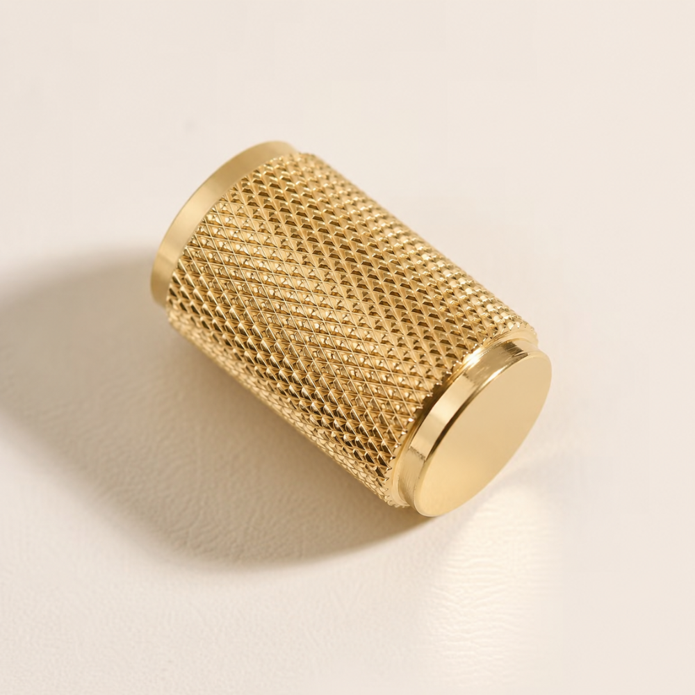 Langer goldener gerändelter Zylinderknopf auf hellem Hintergrund