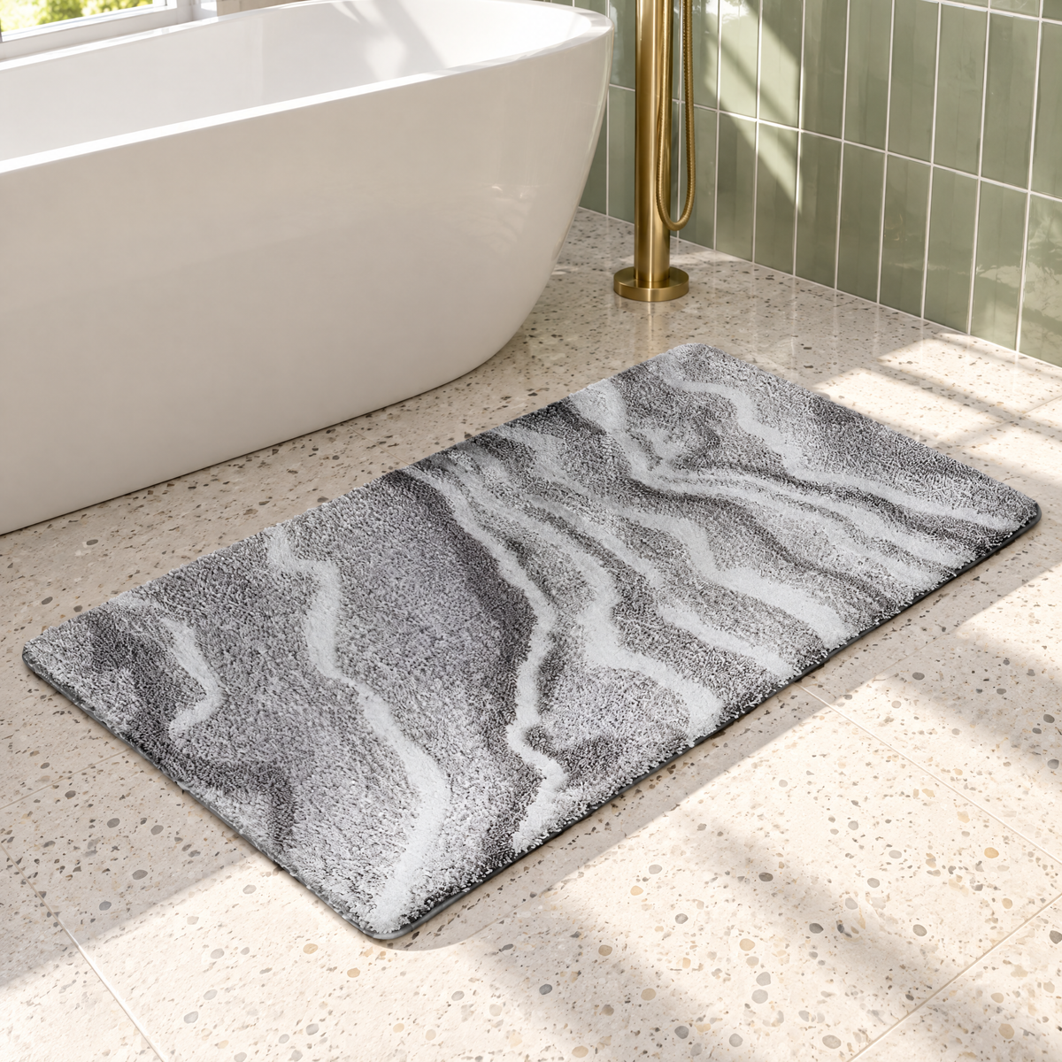 Graue Hochflor-Badematte im Marmor-Look vor einer freistehenden Badewanne