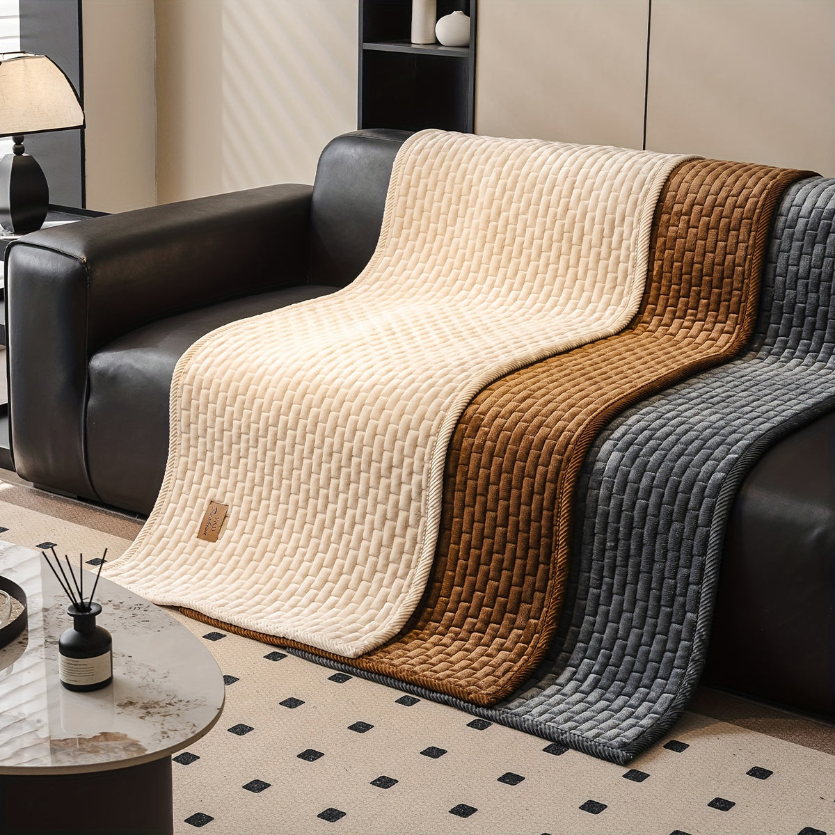 Sofa Überwurf in Creme, Karamellbraun und Dunkelgrau über einem Sofa