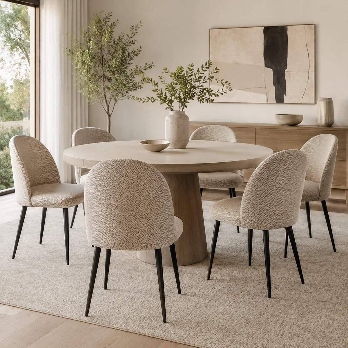 Esszimmer mit Schalenstühlen in beigen Stuhlhussen um einen runden Tisch