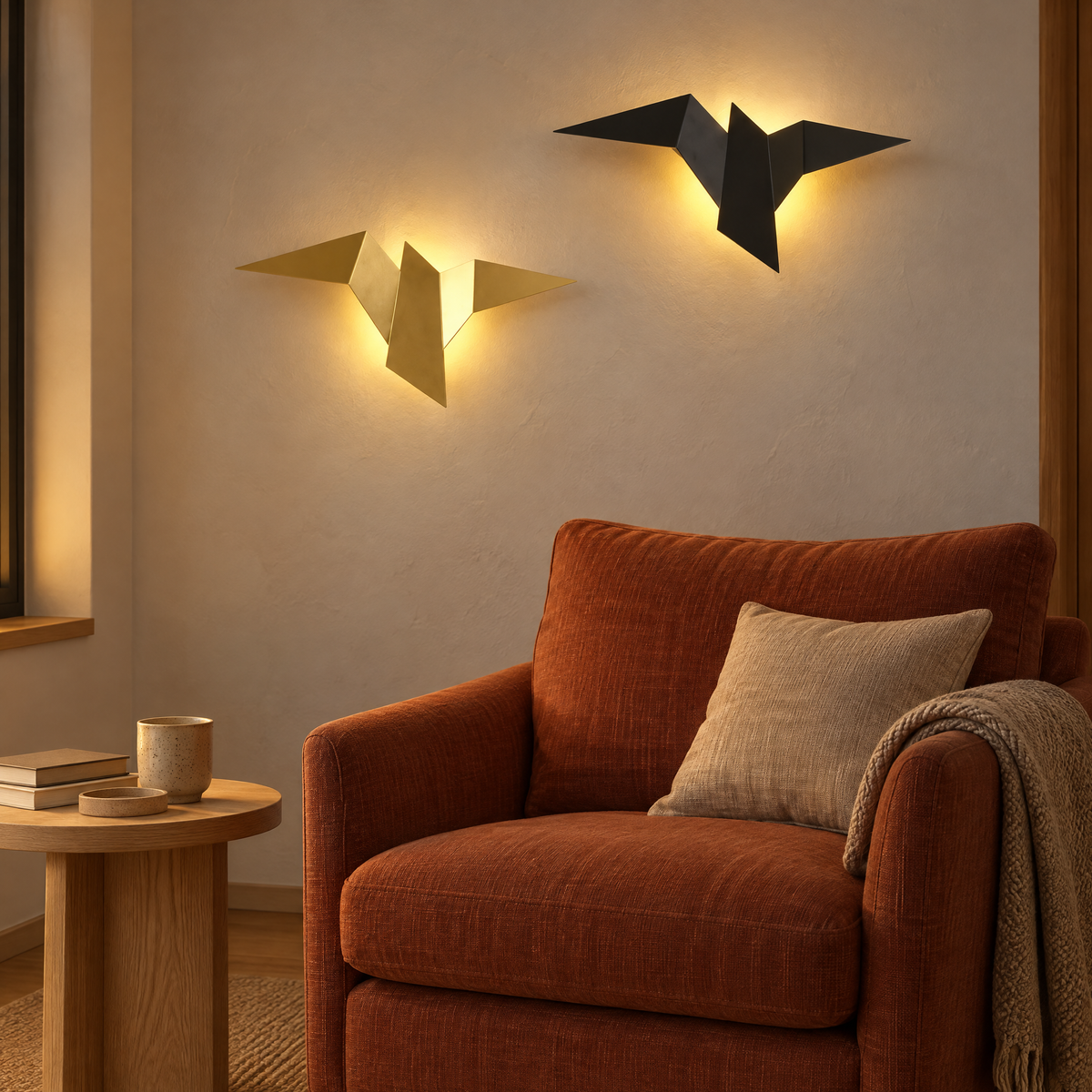 Zwei LED Wandleuchten in Vogelform in Gold und Schwarz über einem Sessel in der Leseecke