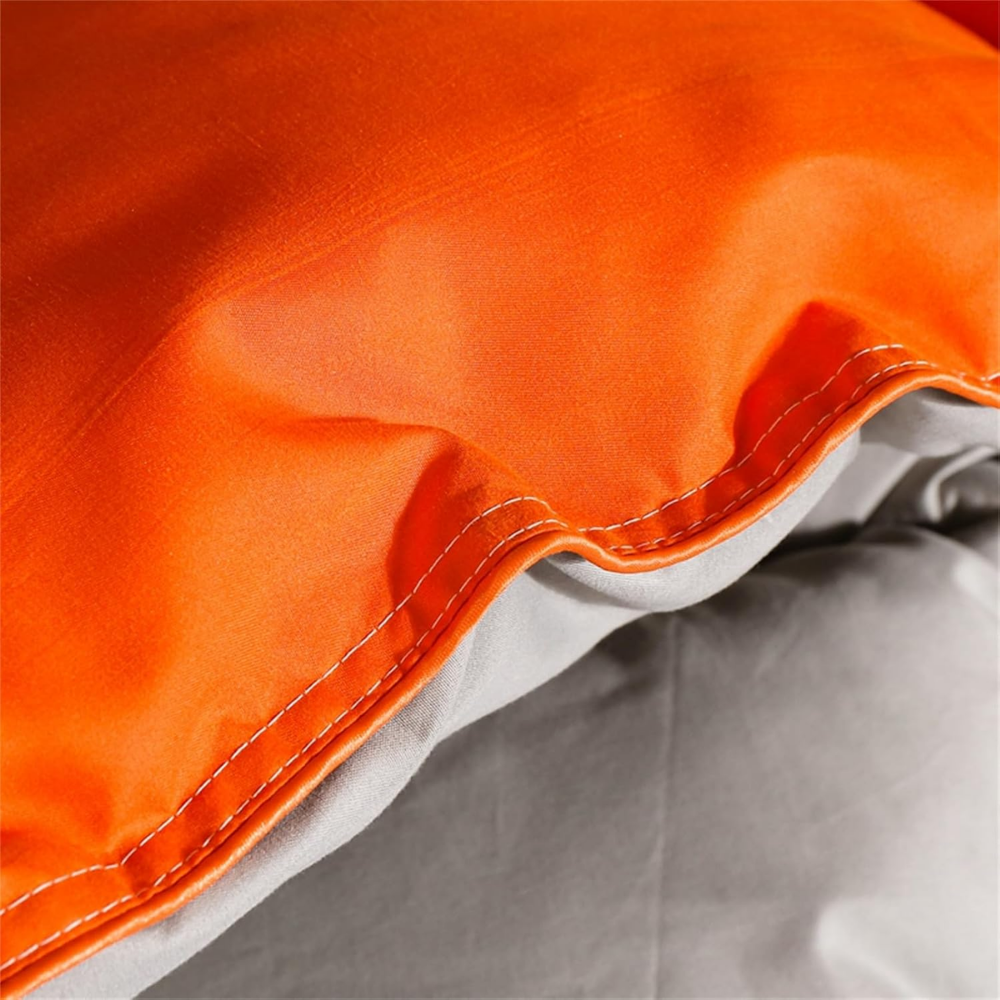 Orangerote Bettdecke mit grauer Unterseite, Nahaufnahme des Rands