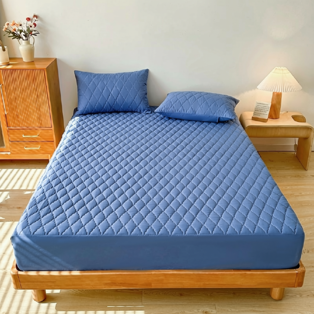 Blauer wasserdichter Matratzenschoner auf einem Holzbett