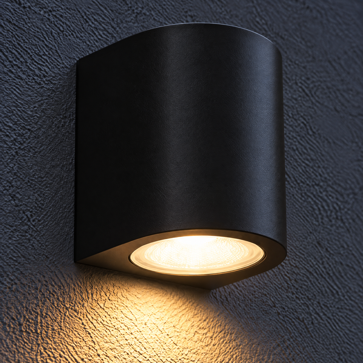 Außenlampe LED halbrund 3 W in Schwarz an dunkler Putzwand, warmweißes Licht fällt aus der Leuchte nach unten