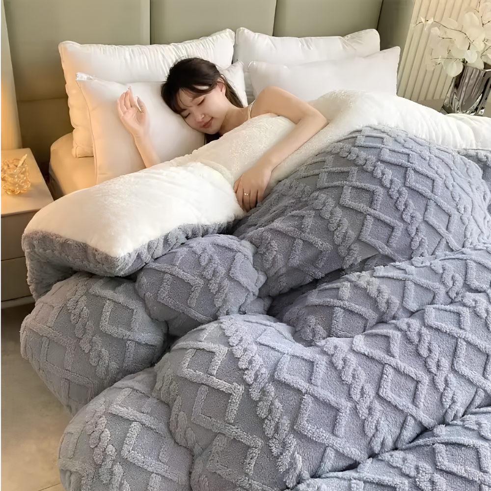 Frau unter einer grauen Winterbettdecke im Schlafzimmer