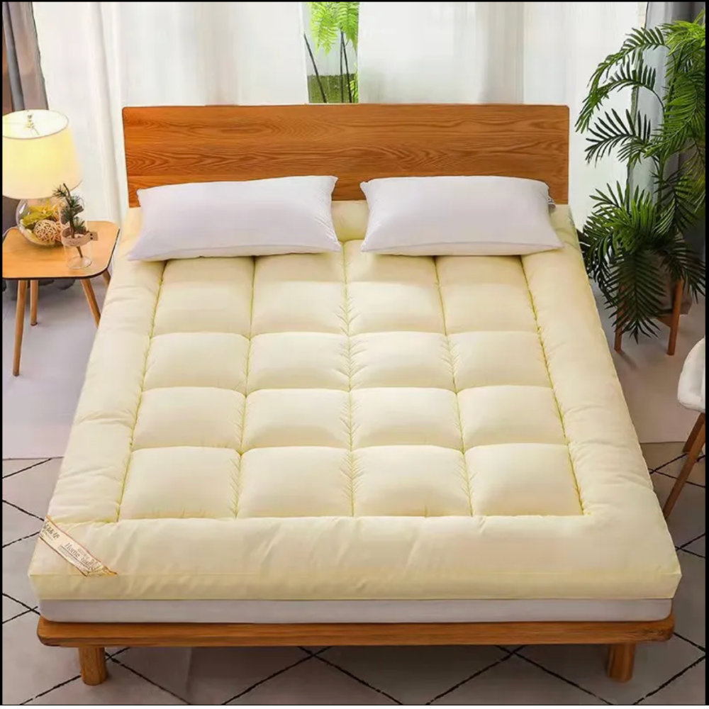 Cremefarbener Matratzentopper auf einem Bett im Schlafzimmer