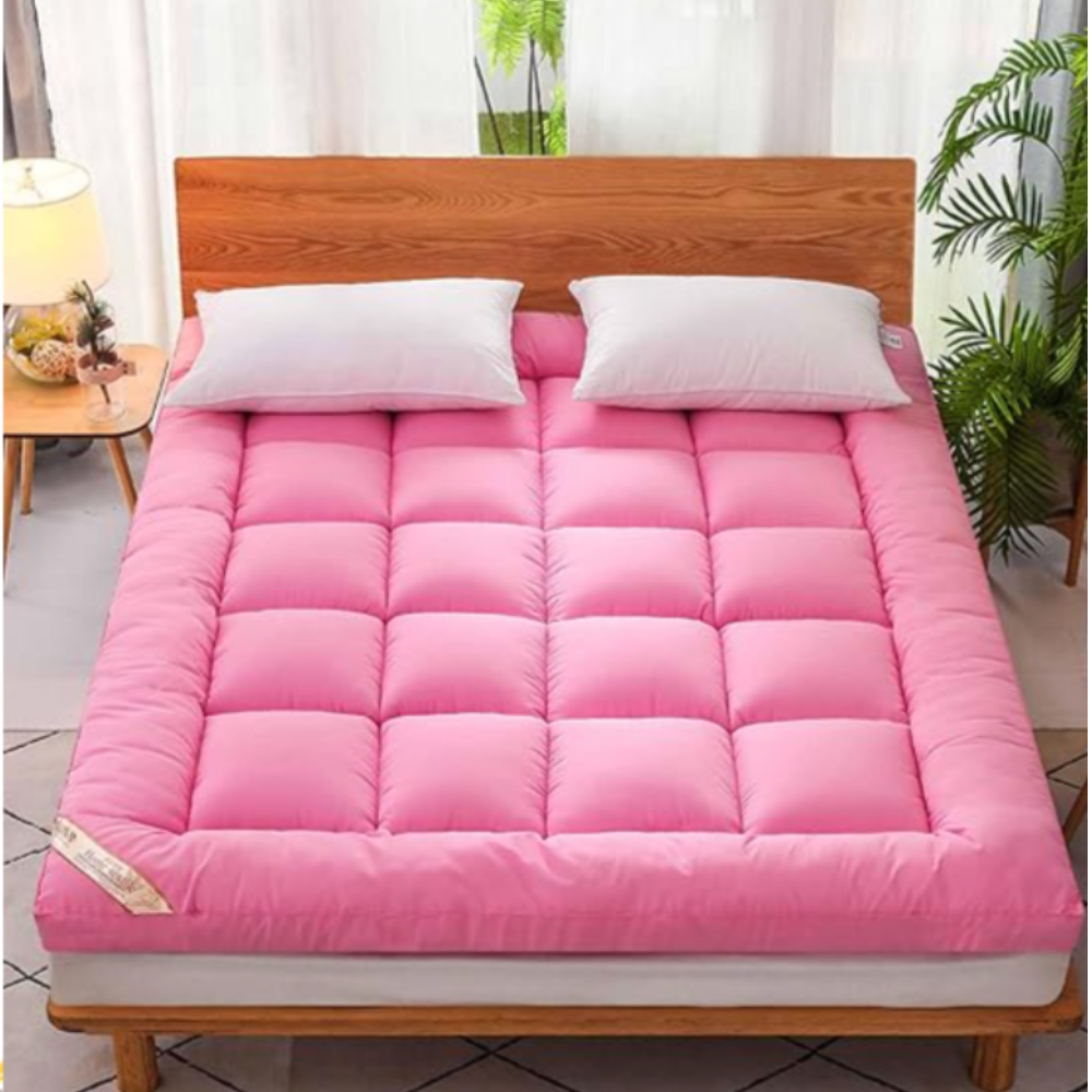 Hellrosa Matratzentopper auf einem Holzbett