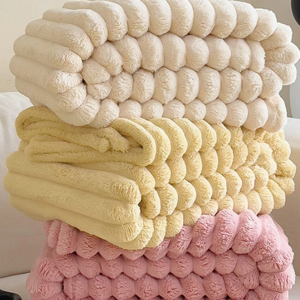 Zusammengelegte Kunstfelldecken in Creme, Gelb und Rosa