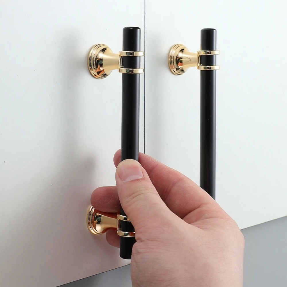 Schwarze T-Bar Griffe mit Gold an einer weißen Tür