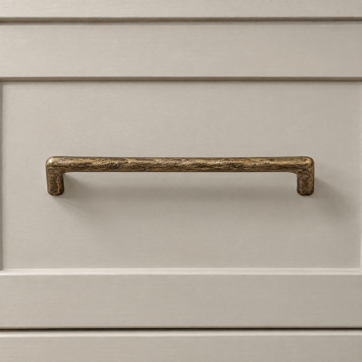 Stangengriff in Antikbronze mit Lochabstand 128 mm an einer beigen Schublade