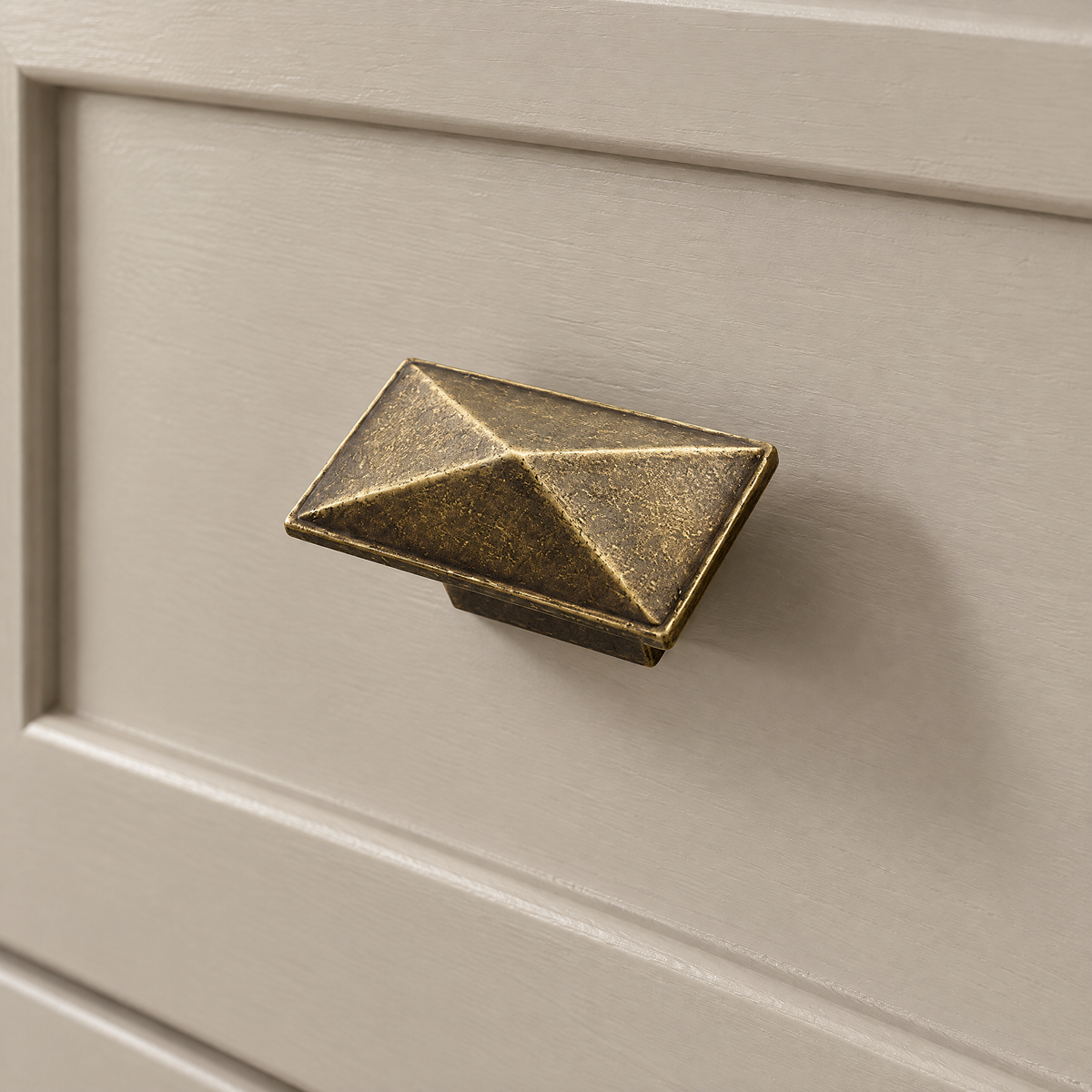 Pyramidenknopf in Antikbronze an einer beigen Schublade