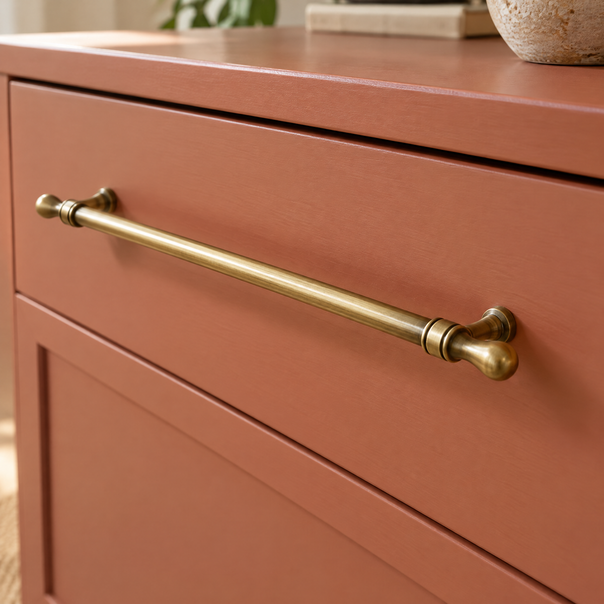 Vintage Möbelgriff in Antik-Messingoptik, Lochabstand 320 mm, an einem terrakottafarbenen Sideboard