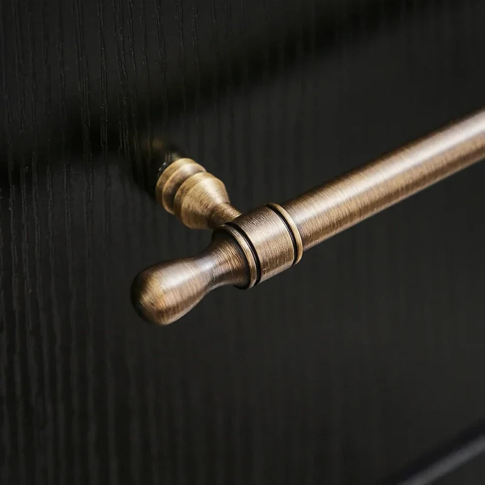 Vintage Möbelgriff in Antik-Messingoptik an einer dunklen Holzfront