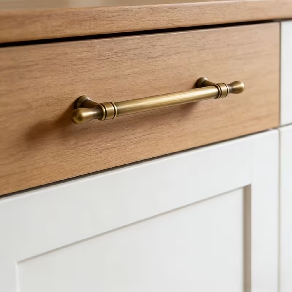 Vintage Möbelgriff in Antik-Messingoptik an einer Schublade mit Holzfront