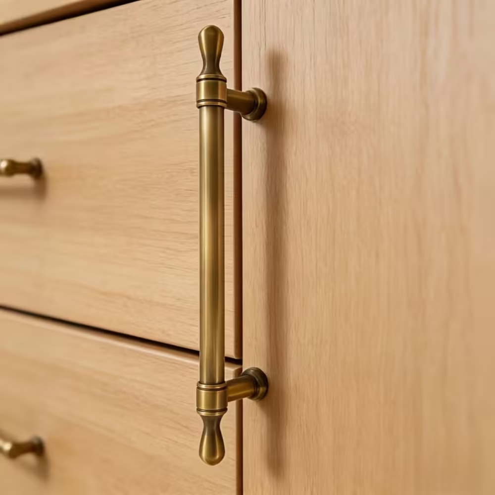 Senkrechter Vintage Griff in Antik-Messingoptik an einem Eichenschrank