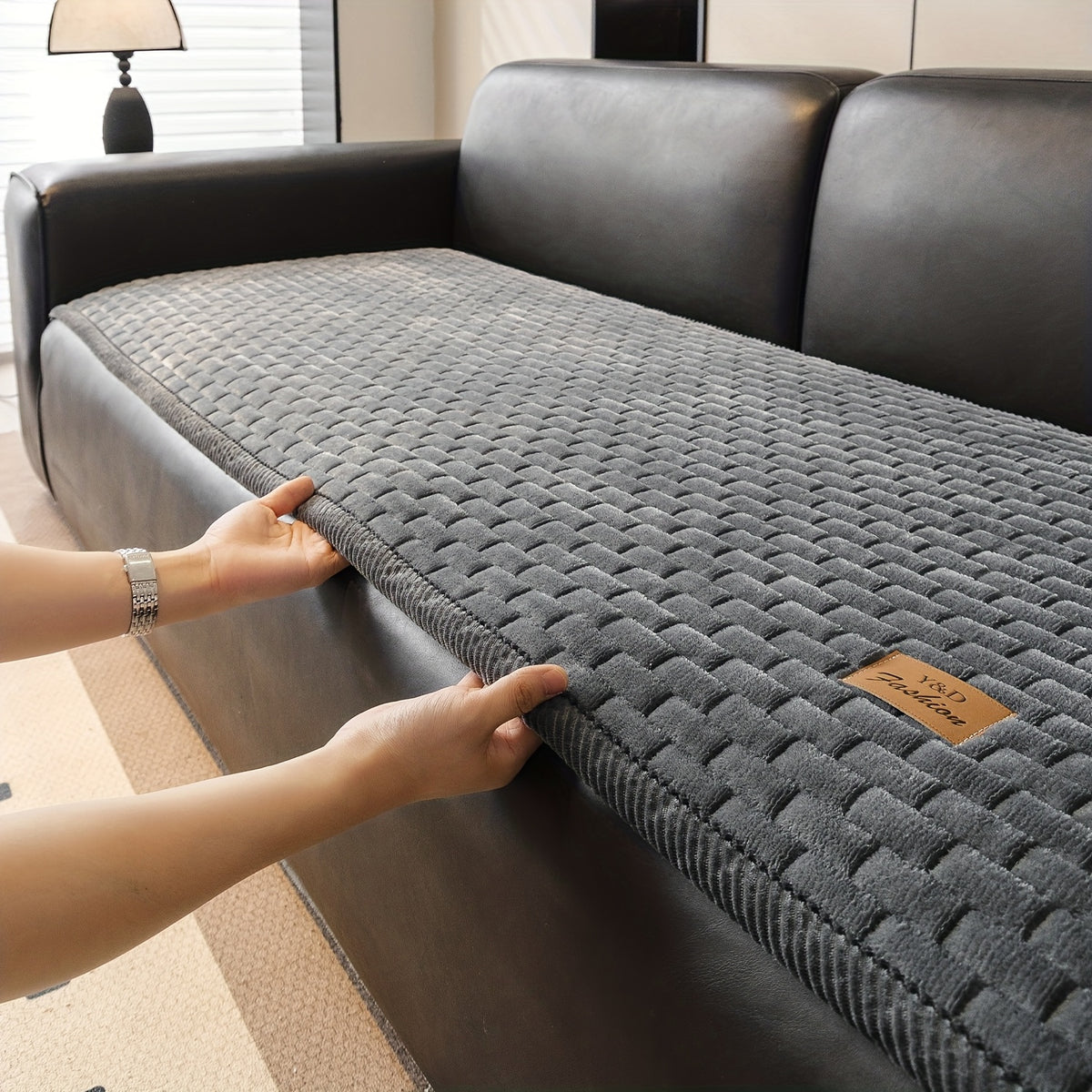 Sofa Überwurf in Dunkelgrau wird auf die Sitzfläche gelegt