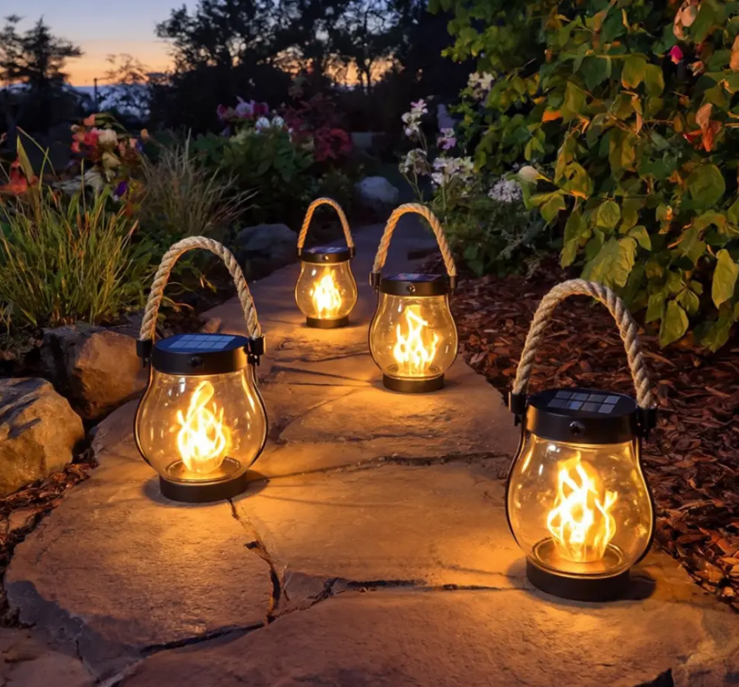 Mehrere Solarlaternen mit klarem Glas entlang eines Gartenwegs