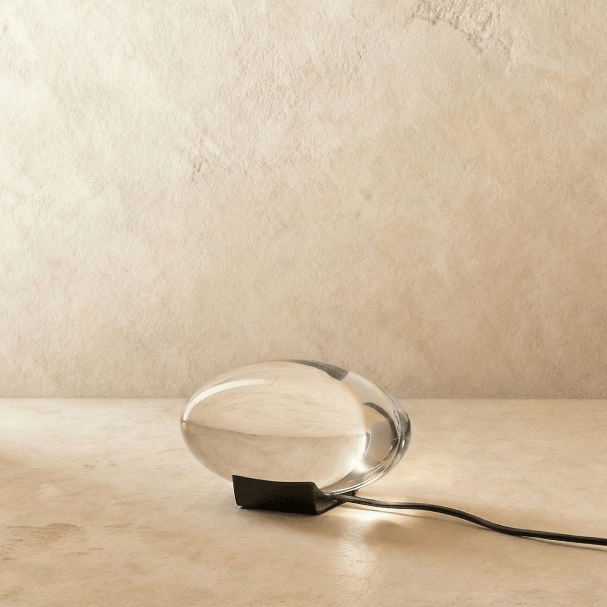 Ausgeschaltete Sunset Lampe: ovaler Acrylkörper auf dunklem Sockel
