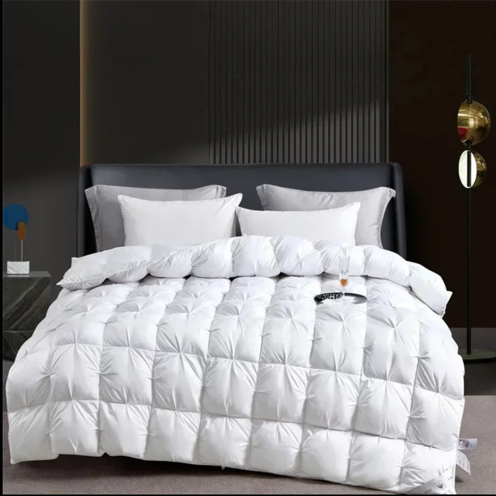 Weiße Winterbettdecke mit Karosteppung auf dem Bett