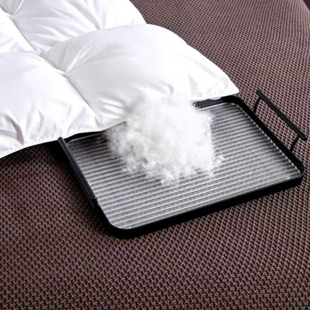 Flauschige Faserfüllung der Winterbettdecke auf einem Tablett