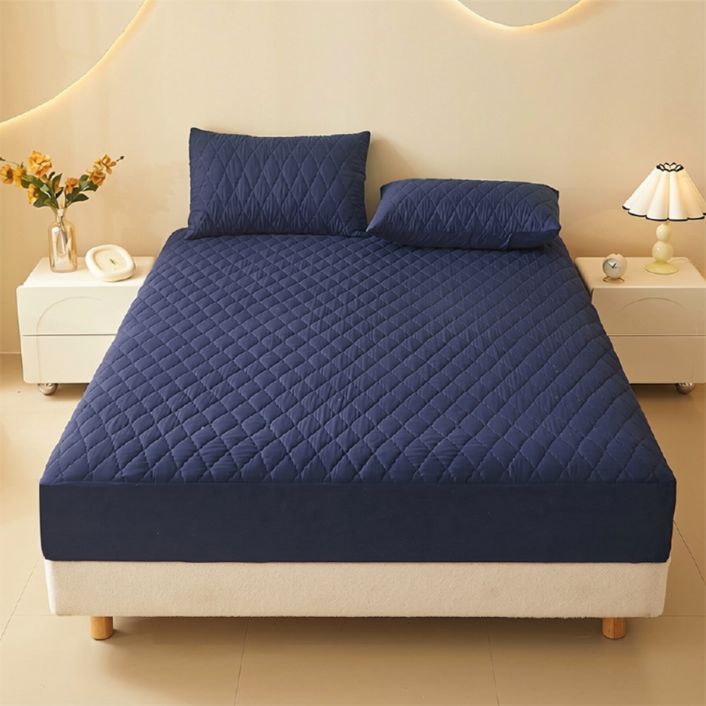 Marineblauer gesteppter Matratzenschoner auf dem Bett