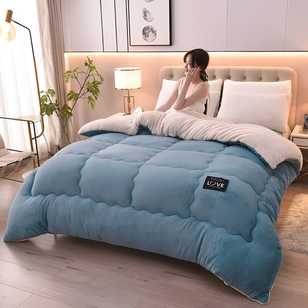 Frau sitzt auf dem Bett mit der hellblauen Winter-Bettdecke